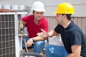 men working on AC unit